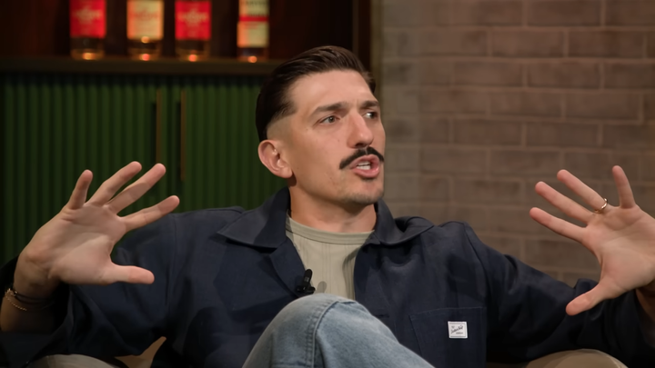 Still image of Andrew Schulz hosting his podcast.